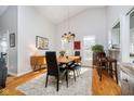 Bright dining room featuring a vaulted ceiling, hardwood floors, and stylish lighting at 8211 River Bay E Dr, Indianapolis, IN 46240