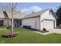 Lovely home with an attached garage, pretty landscaping, and a cozy front porch at 8211 River Bay E Dr, Indianapolis, IN 46240