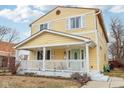 Side view of a yellow two-story home with a cozy front porch and manicured lawn at 854 W Roache St, Indianapolis, IN 46208