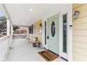 Inviting front porch with a charming mint green door, decorative plants, and ample space for seating at 854 W Roache St, Indianapolis, IN 46208