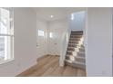 Bright entryway with wood-look floors, white walls and trim, and a carpeted staircase at 9345 Anthem Ave, Plainfield, IN 46168