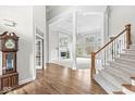 Elegant foyer with hardwood floors, staircase, and view into the open-concept living space at 13701 Cheswick Blvd, Carmel, IN 46032