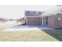 Spacious backyard with a concrete patio and a view of a serene pond in the distance at 1393 N Salem Ct, Greenfield, IN 46140