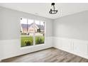 Bright dining room with wainscoting, wood floors, and a view of the front yard at 1393 N Salem Ct, Greenfield, IN 46140