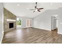 Spacious living room with stone fireplace, high ceilings, fan, and a clear backyard view at 1393 N Salem Ct, Greenfield, IN 46140