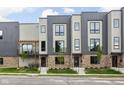 Exterior of modern townhouses showcasing a sleek design with a small deck and lush green lawn at 1517 E New York St, Indianapolis, IN 46201