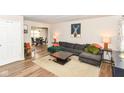 Bright living room with a plush gray sofa, wood-look floors, and an open layout that seamlessly connects to the dining area at 2534 Morning Star Dr, Indianapolis, IN 46229