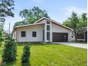 Beautiful modern home with a sleek dark garage door, striking windows, and fresh green lawn at 2689 Pearl St, Columbus, IN 47201
