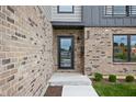Exterior front door with brick facade, glass door, concrete walkway, and low landscaping at 326 N Summit St, Indianapolis, IN 46201