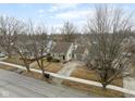 An aerial shot shows this charming tan house with an attached garage in a quiet neighborhood at 354 W 38Th St, Anderson, IN 46013