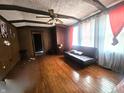 Cozy living room featuring hardwood floors, ceiling fan, and ample natural light at 3624 Columbus Ave, Anderson, IN 46013