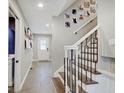 Entryway with stairs, tiled floor and white walls decorated with photos at 3659 Watson Rd, Indianapolis, IN 46205