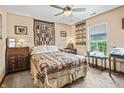 Comfortable bedroom with a ceiling fan, a patterned quilt, and natural light from a window at 4857 W Congress Cv, New Palestine, IN 46163