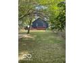 Large backyard featuring a wooden deck, mature trees, and a well-kept lawn at 5206 E St Clair St, Indianapolis, IN 46219