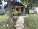 Charming home with a blue exterior, wood siding, and well-manicured lawn at 5206 E St Clair St, Indianapolis, IN 46219