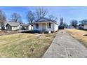 Quaint single-story home with inviting front porch, white siding, and spacious driveway at 613 S Mickley Ave, Indianapolis, IN 46241