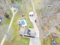 Stunning aerial view of property featuring a pool, detached garage and home with mature trees at 6602 S 400 W, Columbus, IN 47201