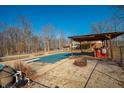 Backyard pool covered for winter with firepit and covered patio at 6602 S 400 W, Columbus, IN 47201