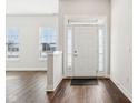 Bright foyer boasts hardwood floors, a white front door with sidelights and transom window, and neutral wall color at 848 Kinzer Ave, Carmel, IN 46032
