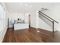 Open-concept living room featuring hardwood flooring, abundant natural light, and stairs with dark metal banisters at 848 Kinzer Ave, Carmel, IN 46032