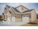 Stylish two-story home with an attached three-car garage featuring stone and brick accents at 9658 Farragut, Indianapolis, IN 46256
