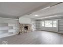 Spacious living room with stone fireplace, built-in shelving, and large window at 1002 Payton Ave, Indianapolis, IN 46219
