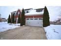 Two-story brick home with white garage door, evergreen trees, and snow covered yard and driveway at 1169 Richmond Ln, Greenwood, IN 46143