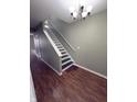 Stylish staircase with hardwood floors, modern lighting, and neutral wall paint, and a white handrail at 1881 Harvest Meadow Dr, Greenwood, IN 46143