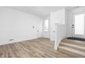 Bright living room featuring hardwood floors, white walls, and a staircase at 2149 N College Ave, Indianapolis, IN 46202