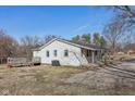 A house with a covered porch and deck surrounded by mature trees in a yard at 27 State Road 42 W, Mooresville, IN 46158