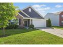 Charming home with a two-car garage, brick accents, and a well-maintained lawn and landscaping at 4236 Stubbington Ln, Indianapolis, IN 46239