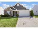 Charming home with a two-car garage, brick accents, and a well-maintained lawn and landscaping at 4236 Stubbington Ln, Indianapolis, IN 46239