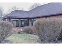 Lovely backyard featuring a sunroom addition, surrounded by mature landscaping and a well-kept lawn at 447 Eagle Crest Dr, Brownsburg, IN 46112