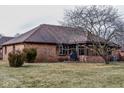 Spacious backyard showcasing mature trees, a manicured lawn, and an enclosed sunroom extension at 447 Eagle Crest Dr, Brownsburg, IN 46112