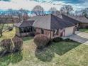 Ranch-style home with brick exterior, attached garage, and sunroom, plus manicured lawn and garden at 447 Eagle Crest Dr, Brownsburg, IN 46112