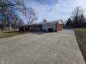 Property featuring brick and vinyl siding, an attached two-car garage and a large concrete driveway at 4601 W Bradford Dr, Muncie, IN 47304