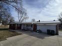 Property featuring brick and vinyl siding, an attached two-car garage and a large concrete driveway at 4601 W Bradford Dr, Muncie, IN 47304