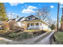 Inviting home with a quaint front porch, complemented by mature trees and a long driveway in a serene setting at 529 W 42Nd St, Indianapolis, IN 46208