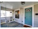 Charming front porch with a cozy swing, a 'welcome' sign, and a bright teal door inviting relaxation and charm at 529 W 42Nd St, Indianapolis, IN 46208