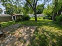 Lush backyard featuring a storage shed and mature trees, offering a private outdoor space at 603 W 33Rd St, Anderson, IN 46013