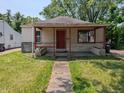 Charming bungalow-style house with a red front door and covered front porch at 603 W 33Rd St, Anderson, IN 46013