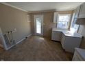 A kitchen with white cabinets, a window, and a door to the outside at 603 W 33Rd St, Anderson, IN 46013