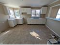Kitchen featuring white cabinets, neutral countertops, double sink, and tile flooring at 603 W 33Rd St, Anderson, IN 46013