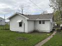 Rear view of a cozy home with a tidy yard and accessible walkway at 605 W 10Th St, Muncie, IN 47302