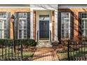 The house has a well landscaped brick walkway leading up to a black front door flanked by black shutters and columns at 8044 Clymer Ln, Indianapolis, IN 46250