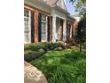 Traditional brick home with black shutters, mature landscaping and a meticulously maintained lawn at 8044 Clymer Ln, Indianapolis, IN 46250