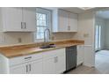 Bright kitchen features white cabinets, stainless steel sink with a wood countertop and stainless steel dishwasher at 104 Walnut Ct, Noblesville, IN 46062