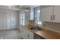 Bright kitchen features white cabinets, stainless steel sink with a wood countertop, and modern appliances at 104 Walnut Ct, Noblesville, IN 46062