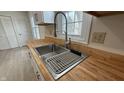 Stainless steel kitchen sink, wood countertop, with modern faucet fixtures under a window at 104 Walnut Ct, Noblesville, IN 46062