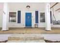 Close-up of a front porch featuring a bright blue door, white columns, and a porch swing at 122 S Green St, Brownsburg, IN 46112